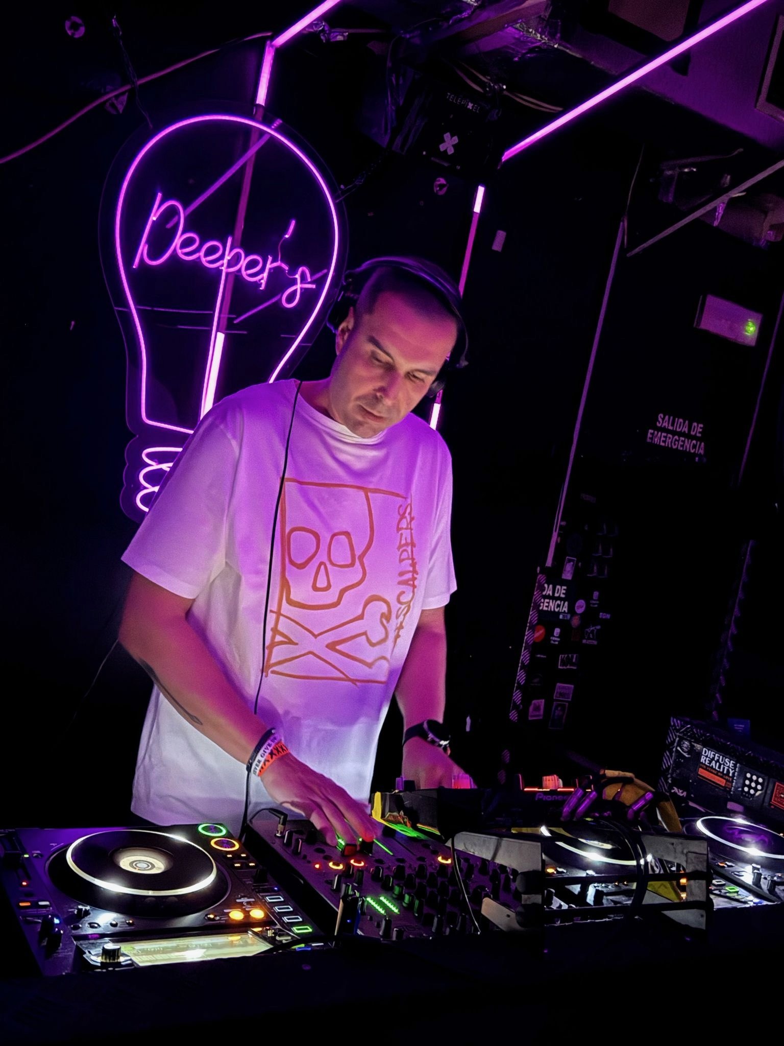 Manu Lessor pinchando en cabina, con los CDJ y el mixer delante
